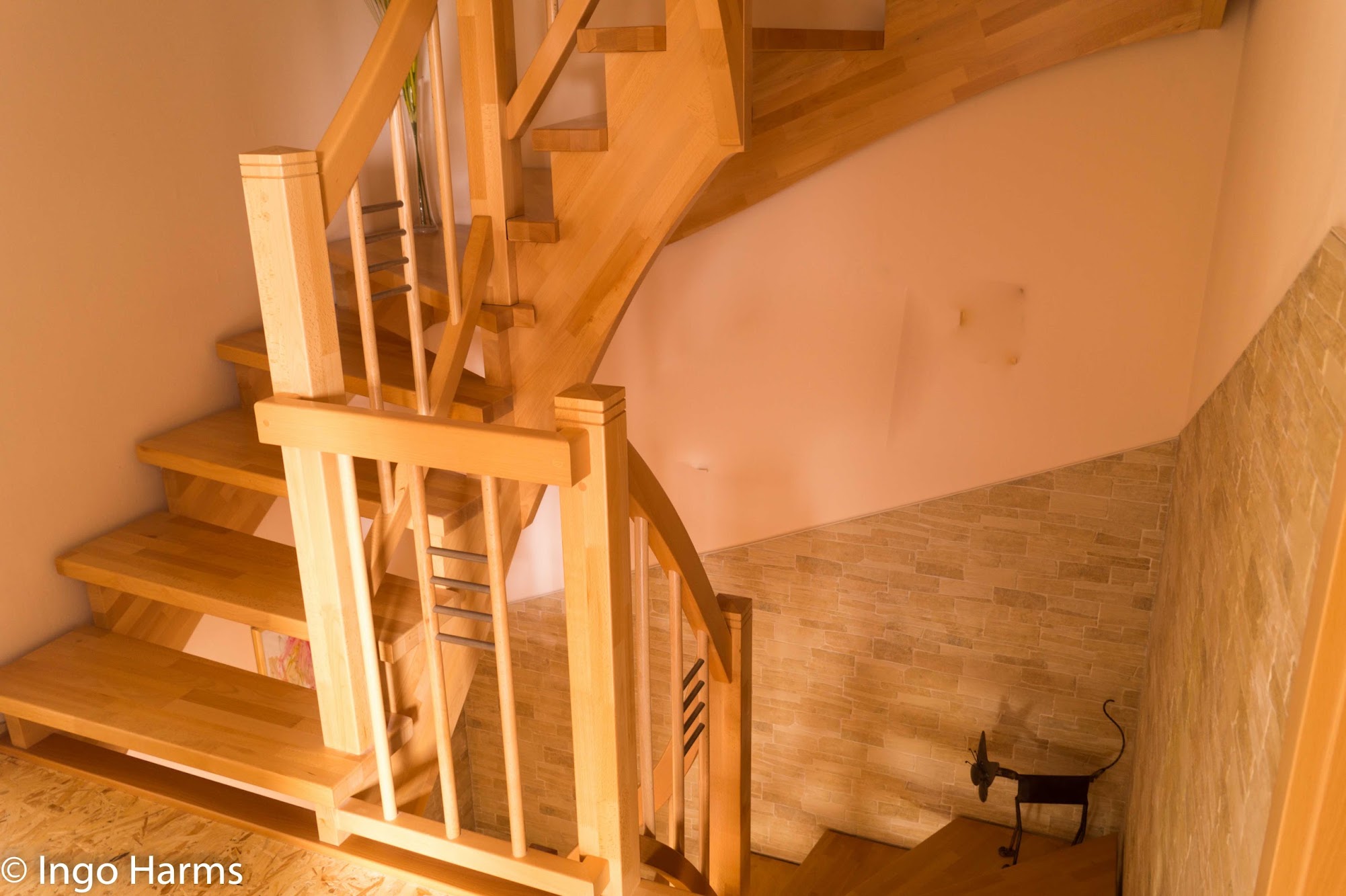 Gewendelte Holztreppe mit Metallstäben im Geländer